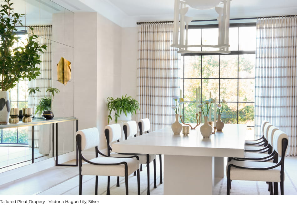 A dining room finished with Tailored Pleat Drapery made from Victoria Hagan Lily embroidered plaid fabric in a Silver color.